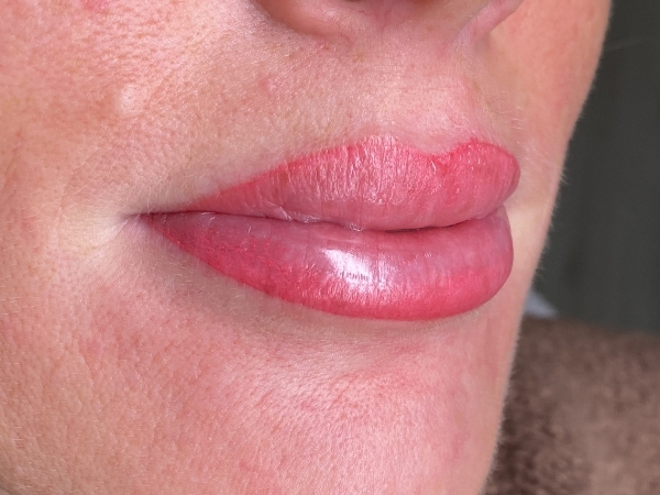 Nafoto van lippen na een lip PMU-behandeling met een vollere en egalere kleur.